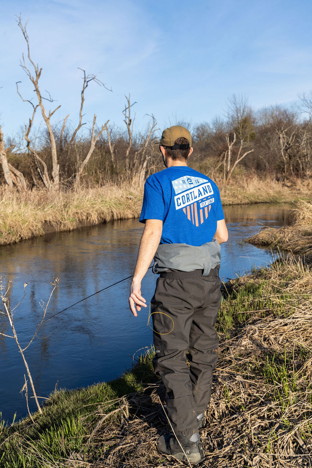 A man is fishing with his back to the camera 