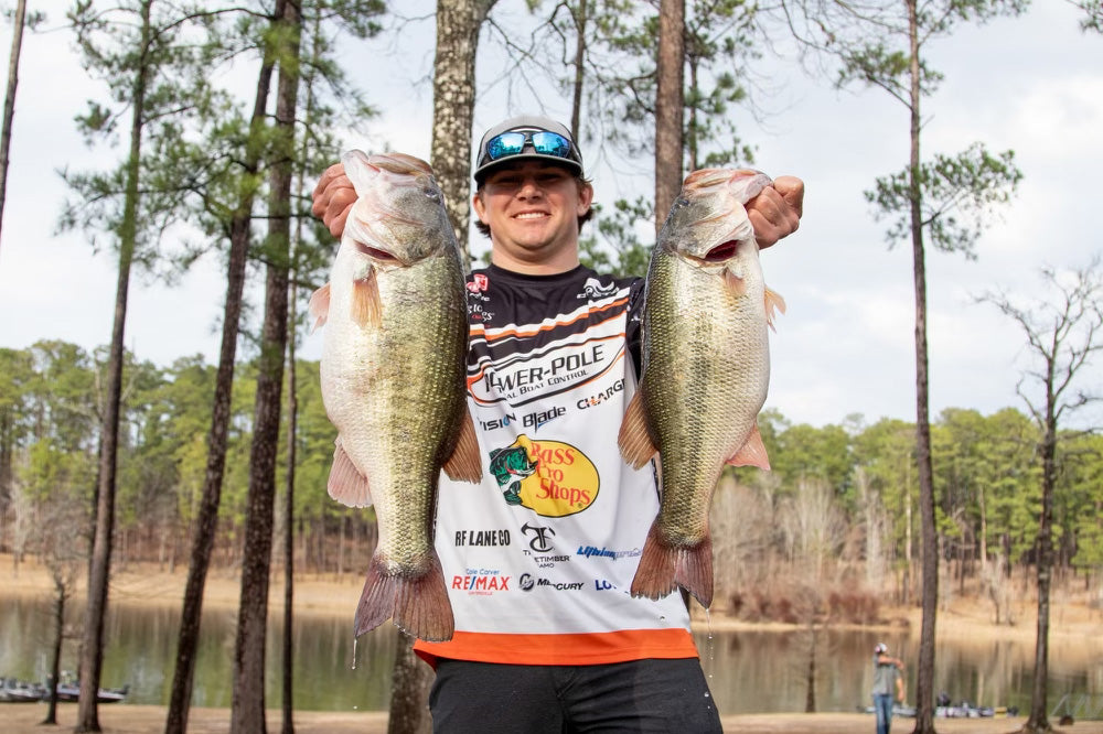 Cal holding up two fish and smiling