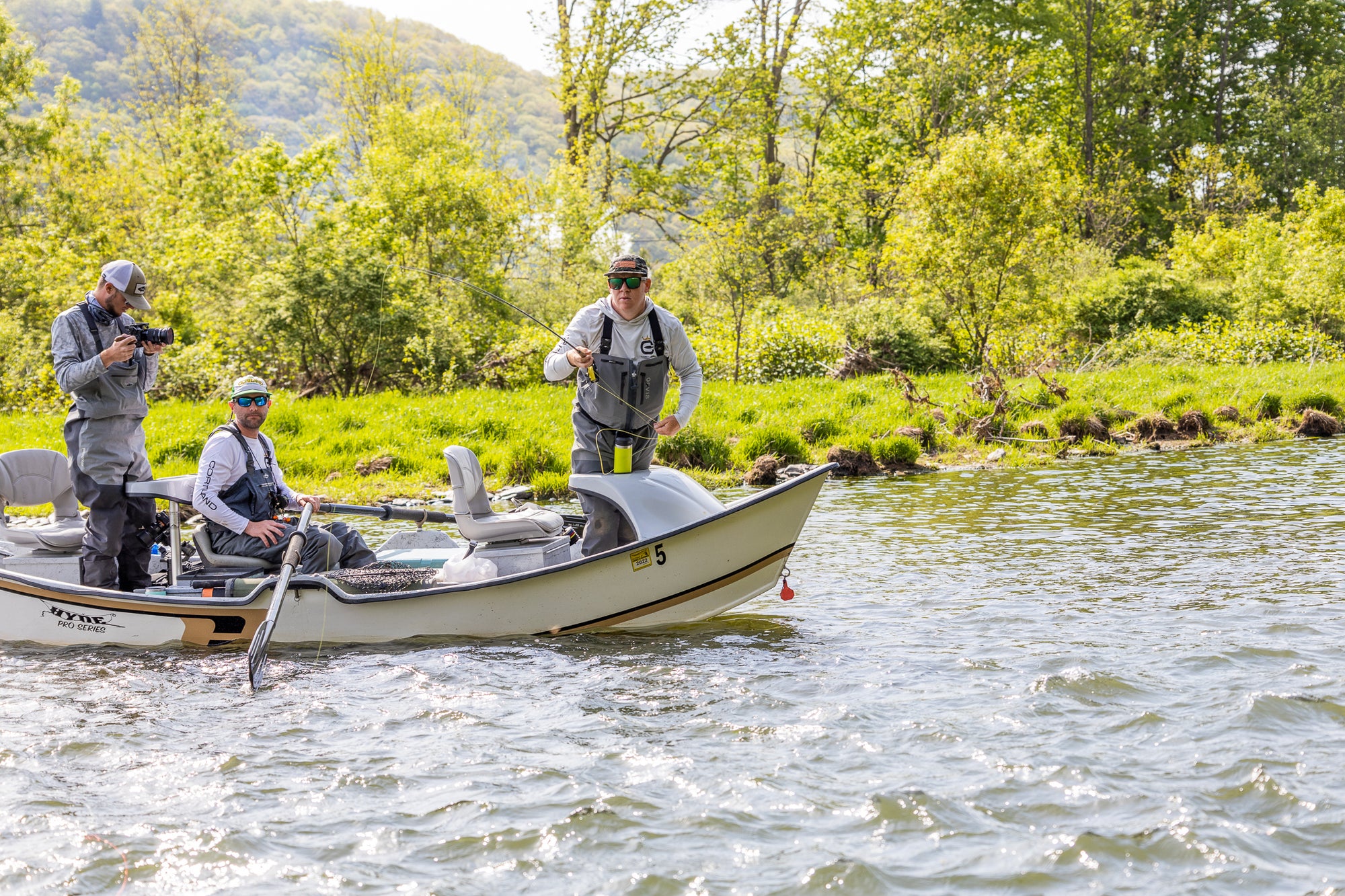 Three fishermen on a boat getting ready to dry fly fish 