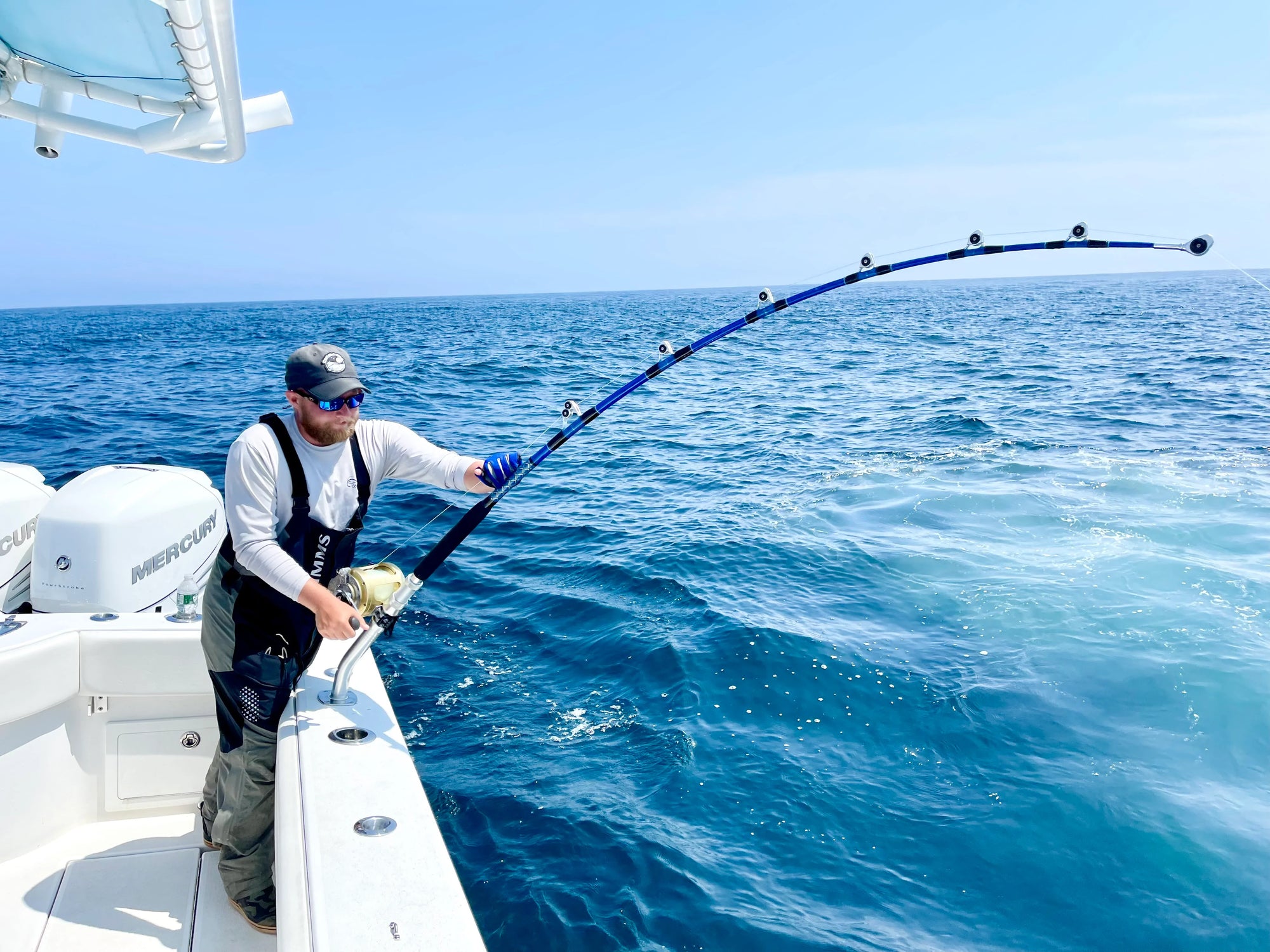 Man on a boat casting out a line into the ocean