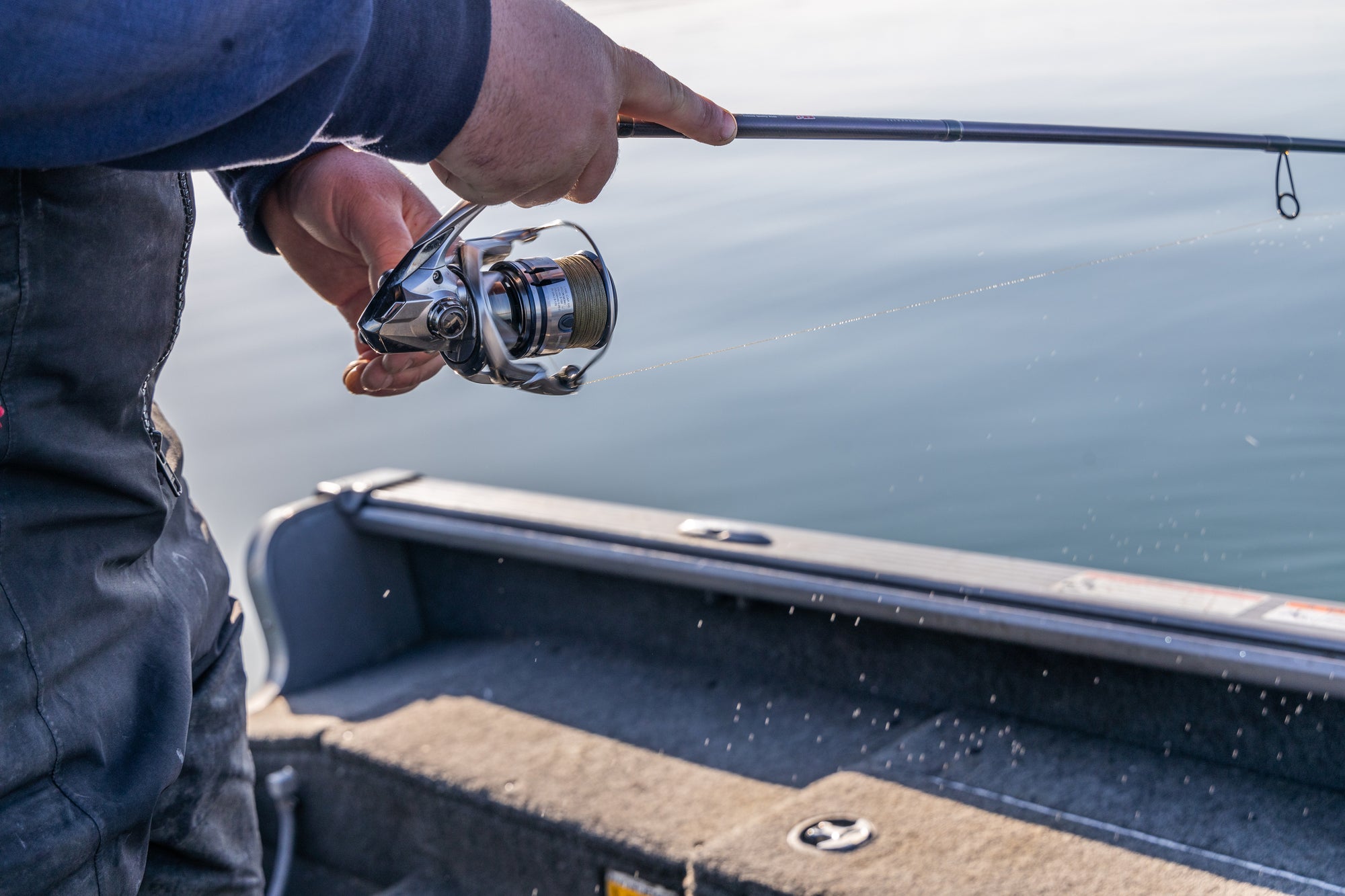 Closeup of someone&#39;s hands reeling in their fishing pole. 