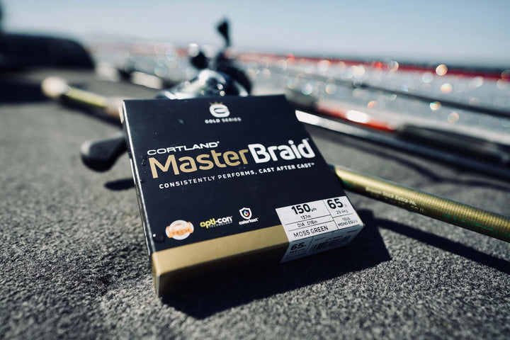 Master Braid Moss Green in its box with fly rods in the background 
