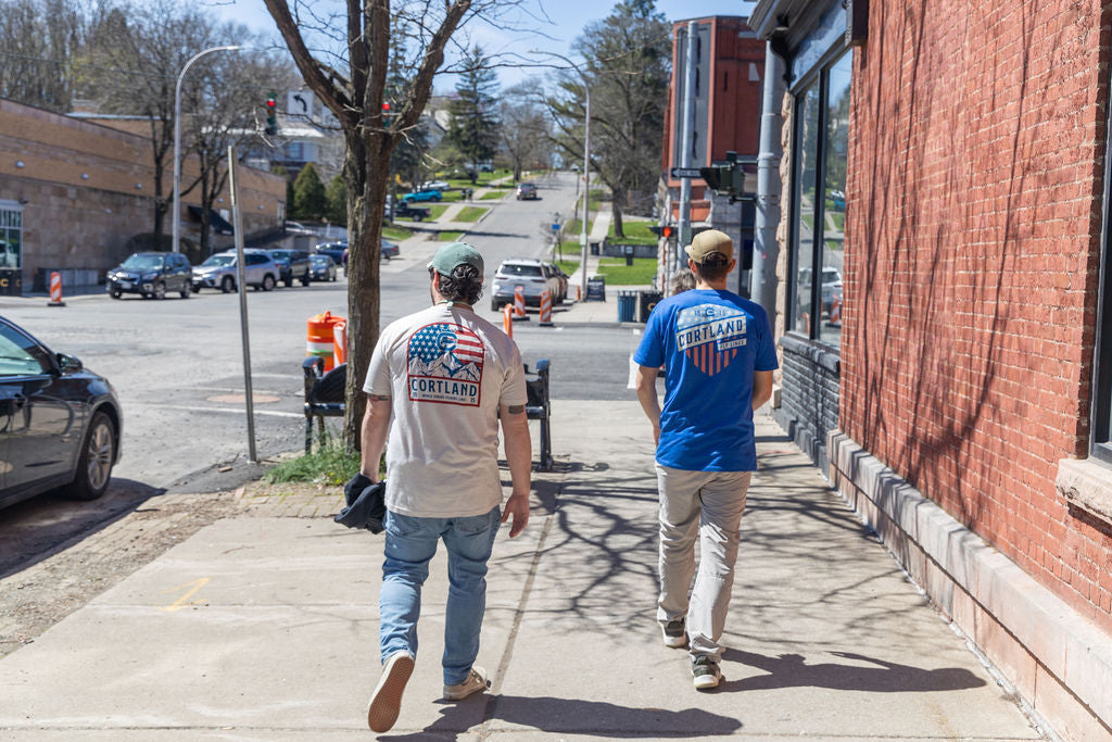 Two guys walking down a street 