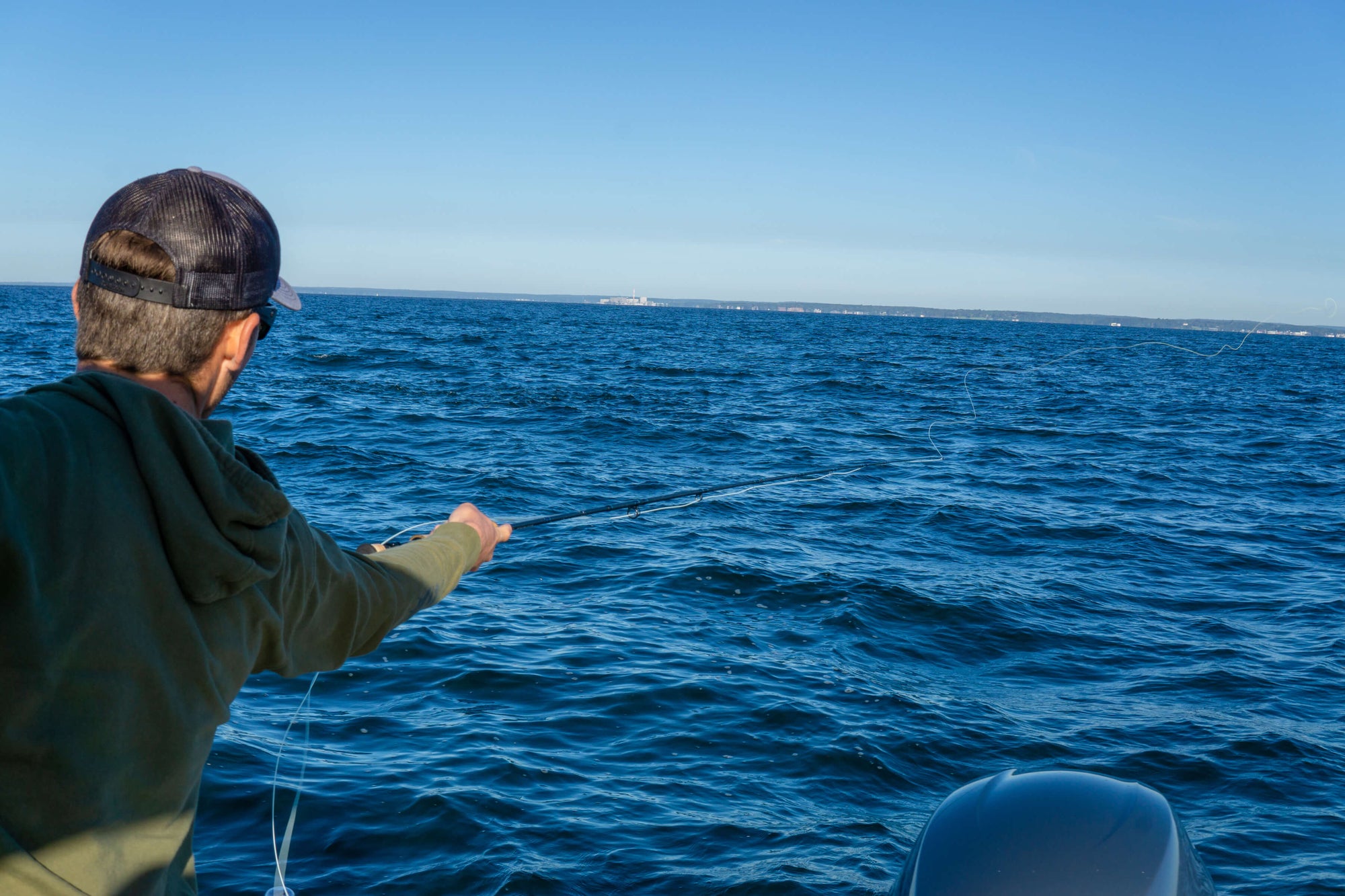 There is a fisherman casting his fishing line