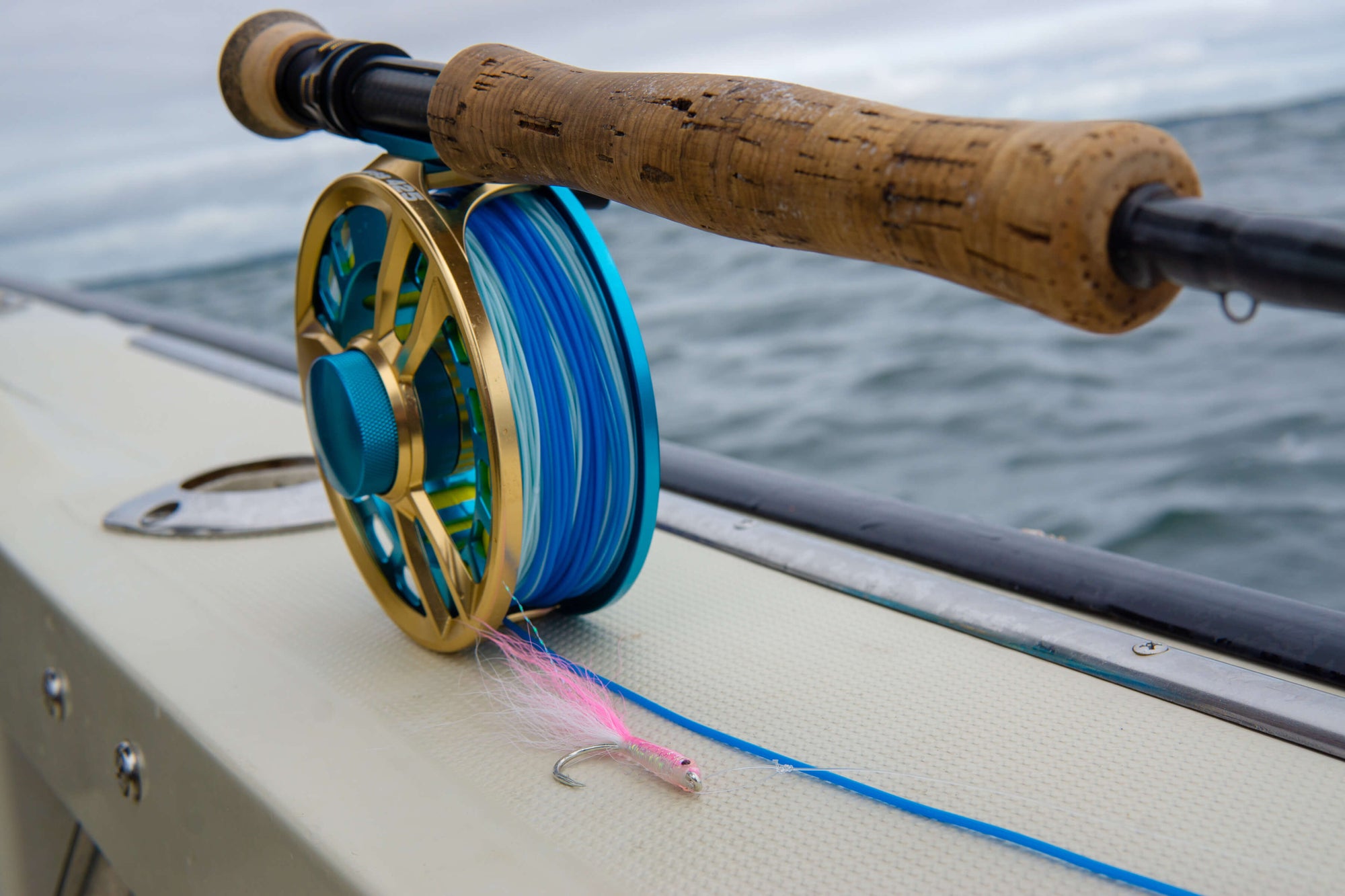 Fly Rod on the edge of a boat, with water in the background 