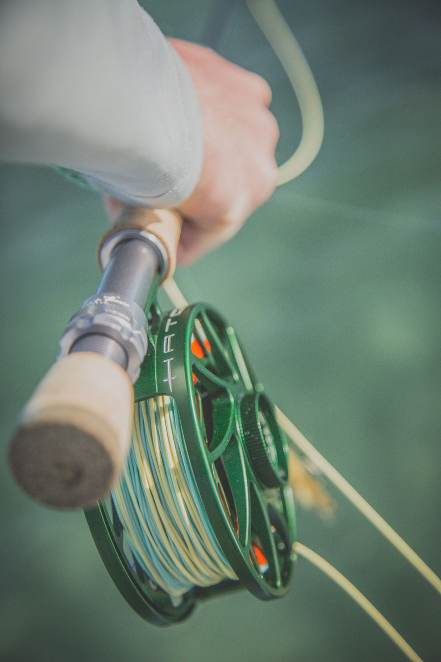 Closeup shot of someone holding onto their fly rod. 