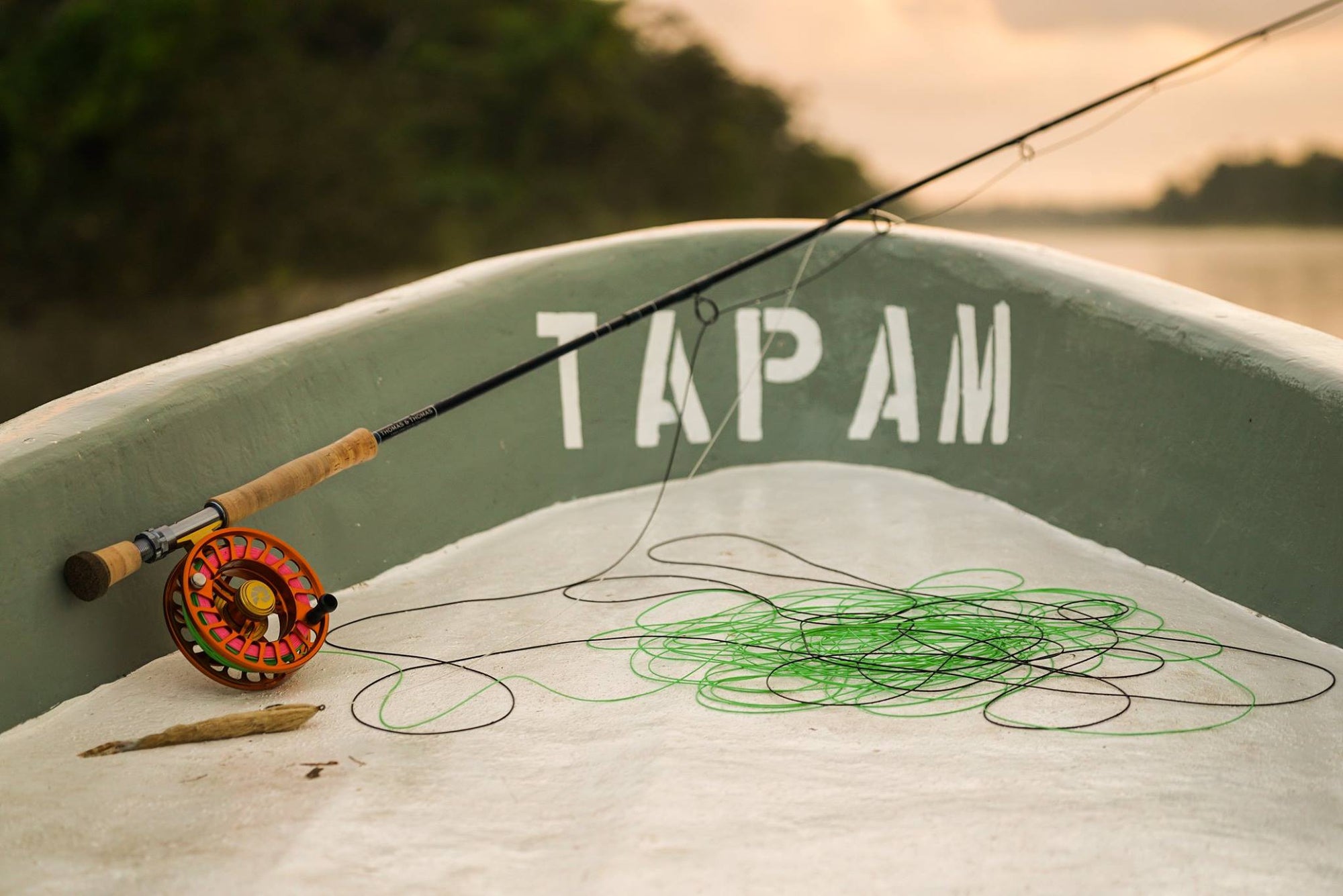 Fly fishing rod leaning up against the bow of a boat. 